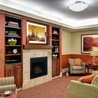 A cozy living room featuring a fireplace, bookshelves, and comfortable seating.