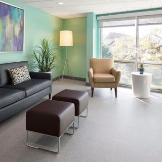 A modern waiting room featuring comfortable seating, natural light, and contemporary decor.