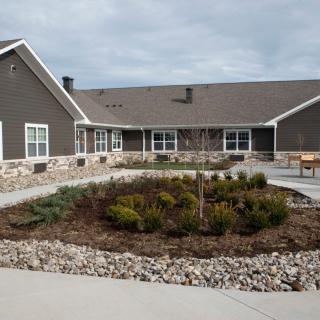 A view of a residential building with a well-maintained garden in front.