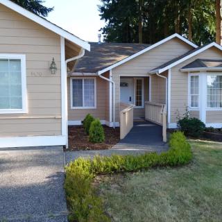 A single-story house with a landscaped front yard and a walkway leading to the entrance.