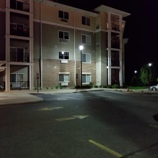 A quiet apartment building at night, illuminated by street lights.