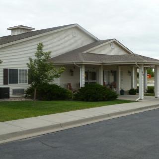 A suburban residential house with a porch and well-maintained landscaping.