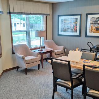 A modern office meeting room with comfortable seating and framed artwork.