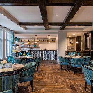 A modern and cozy restaurant interior with stylish furnishings and wooden flooring.