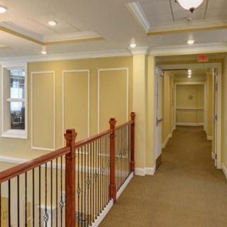 A well-lit hallway with decorative trim and a wooden banister.
