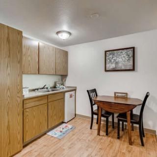 A cozy kitchen with wooden cabinets and a dining area featuring a small table and chairs.
