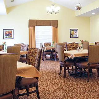 A well-arranged dining area with tables and chairs, featuring elegant decor.