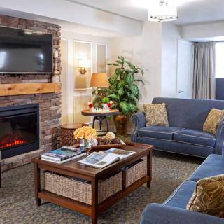 A cozy living room featuring a fireplace, comfortable sofas, and a stylish coffee table.