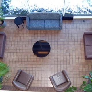 An indoor seating area with sofas, chairs, and a coffee table on tiled flooring.