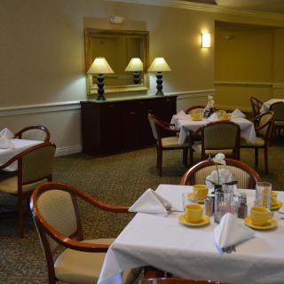 A well-kept dining area with neatly arranged tables and chairs, featuring elegant table settings.