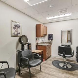 A modern hair salon with styling chairs, a mirror, and professional equipment.
