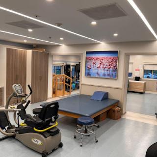 A well-equipped physical therapy room featuring exercise equipment and therapeutic spaces.