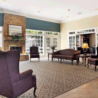 A spacious lobby featuring elegant furniture and a warm fireplace.