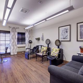 A cozy salon with seating and hair drying stations.