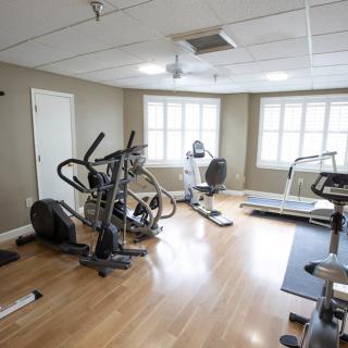 A small home gym with various exercise equipment including a treadmill and elliptical machine.