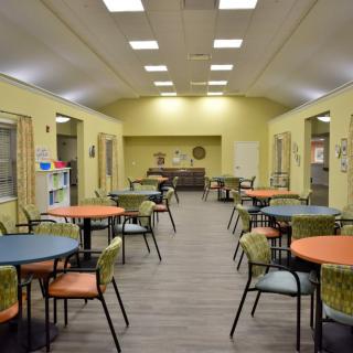 A bright, open community dining area with colorful tables and chairs.