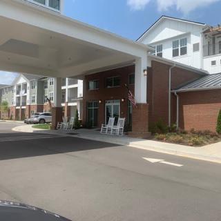 Entrance of a residential building with a covered driveway and seating area.