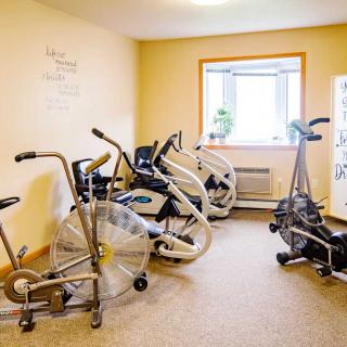 A well-lit exercise room with several stationary bikes for indoor workouts.
