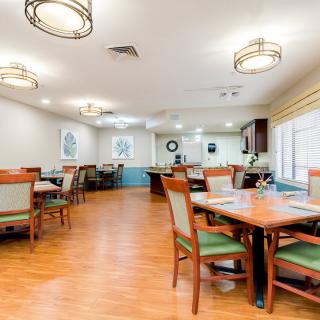 A spacious and well-lit dining room with neatly arranged tables and chairs.
