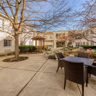 A sunny courtyard with patio furniture and surrounding buildings.