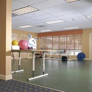 A spacious physical therapy room with exercise equipment and balance balls.
