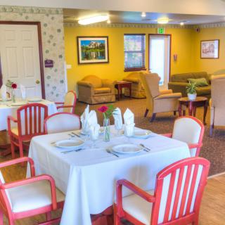 A cozy dining area with neatly set tables and comfortable seating.