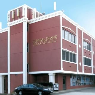 A red brick courthouse building with a car parked in front.
