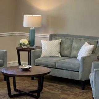 A cozy living room with a sofa, coffee table, and lamp.