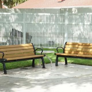 Two wooden benches in a sunny outdoor park area.