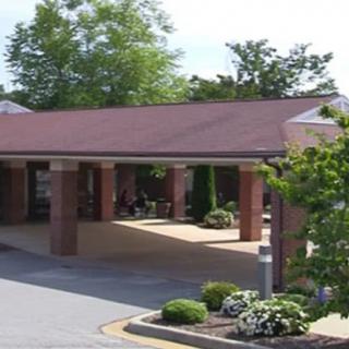 A building entrance surrounded by trees and landscaped plants.