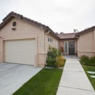 A suburban single-story house with a garage and small front yard.