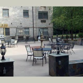 An outdoor patio area with tables and chairs in a courtyard setting.