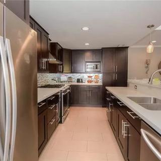 A modern kitchen with stainless steel appliances and dark cabinetry.