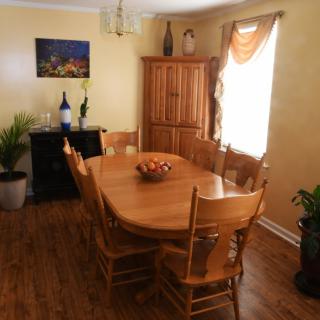 A cozy dining room with wooden furniture and decorative plants.