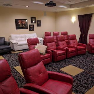 A comfortable home theater featuring red reclining chairs, perfect for movie nights.