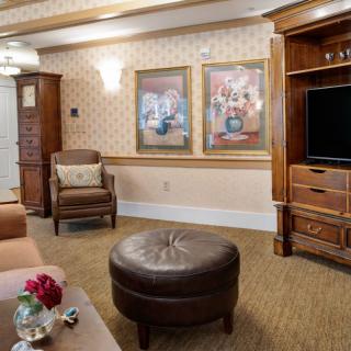 A cozy living room featuring comfortable chairs, a television, and artwork on the walls.