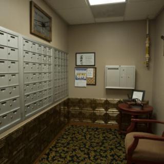 A quiet mailroom with multiple mailboxes and cozy seating.