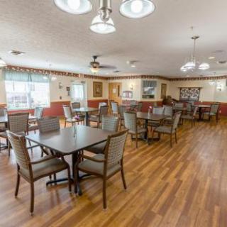 A spacious and well-lit dining area featuring wooden floors and comfortable seating arrangements.