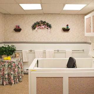 A cozy bathroom with a bathtub, floral decorations, and neatly arranged towels.