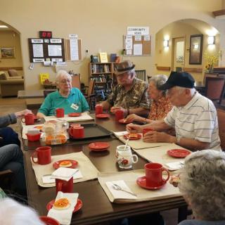 A group of seniors enjoying a meal together at a community center.