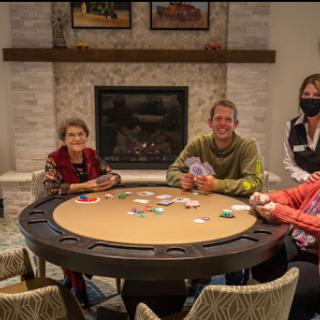 A group of friends enjoying a game of poker around a gaming table in a cozy indoor setting.