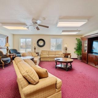 A spacious living room with comfortable seating, a large TV, and natural light.