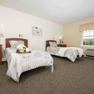 A cozy bedroom with two single beds, decorated in neutral tones.