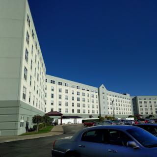 A view of a multi-story hotel building under a clear blue sky.