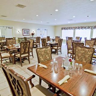 A spacious and elegantly furnished dining room with multiple set tables and chairs.