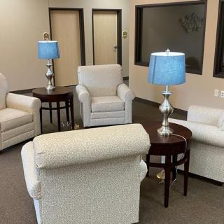 A cozy waiting room featuring comfortable chairs and soft lighting.