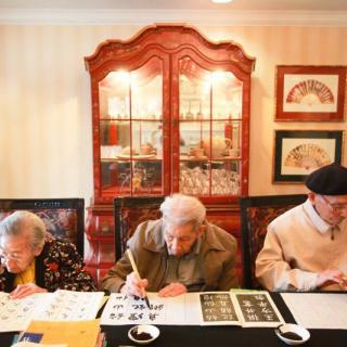 Seniors engaged in calligraphy at a workshop.