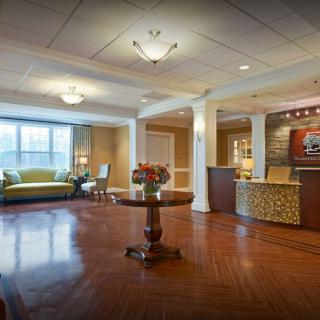A spacious and elegant lobby with a reception desk and seating area.