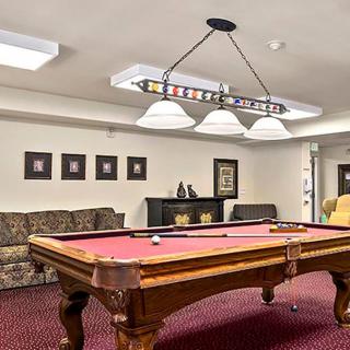 A cozy recreation room featuring a stylish pool table and comfortable seating.
