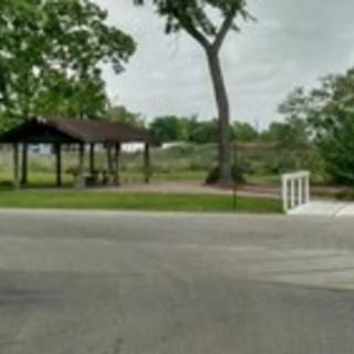A small park area with a pavilion, trees, and a footbridge.
